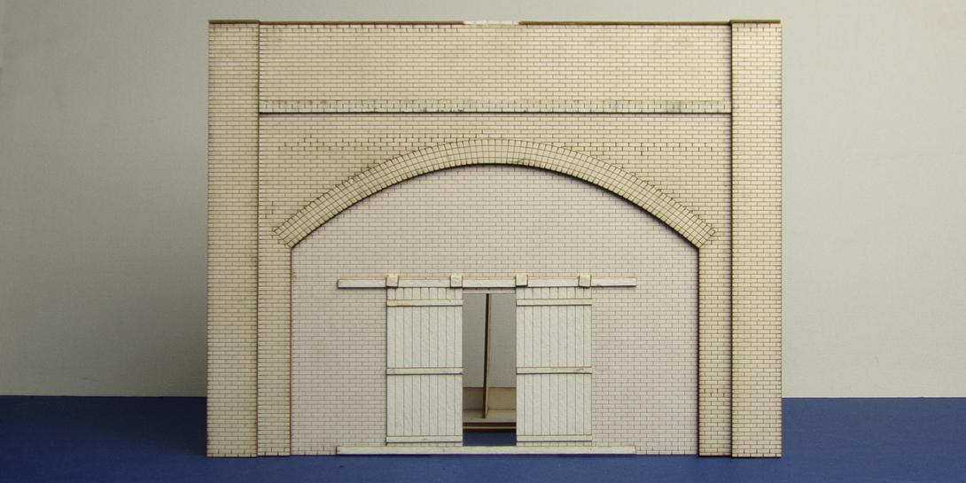 A 70-01 O gauge brick arch with industrial gate O gauge brick arch unit with industrial gate underarch. This bundle includes the face of the arch and the back parapet panel with interlocking left and right brickwork.